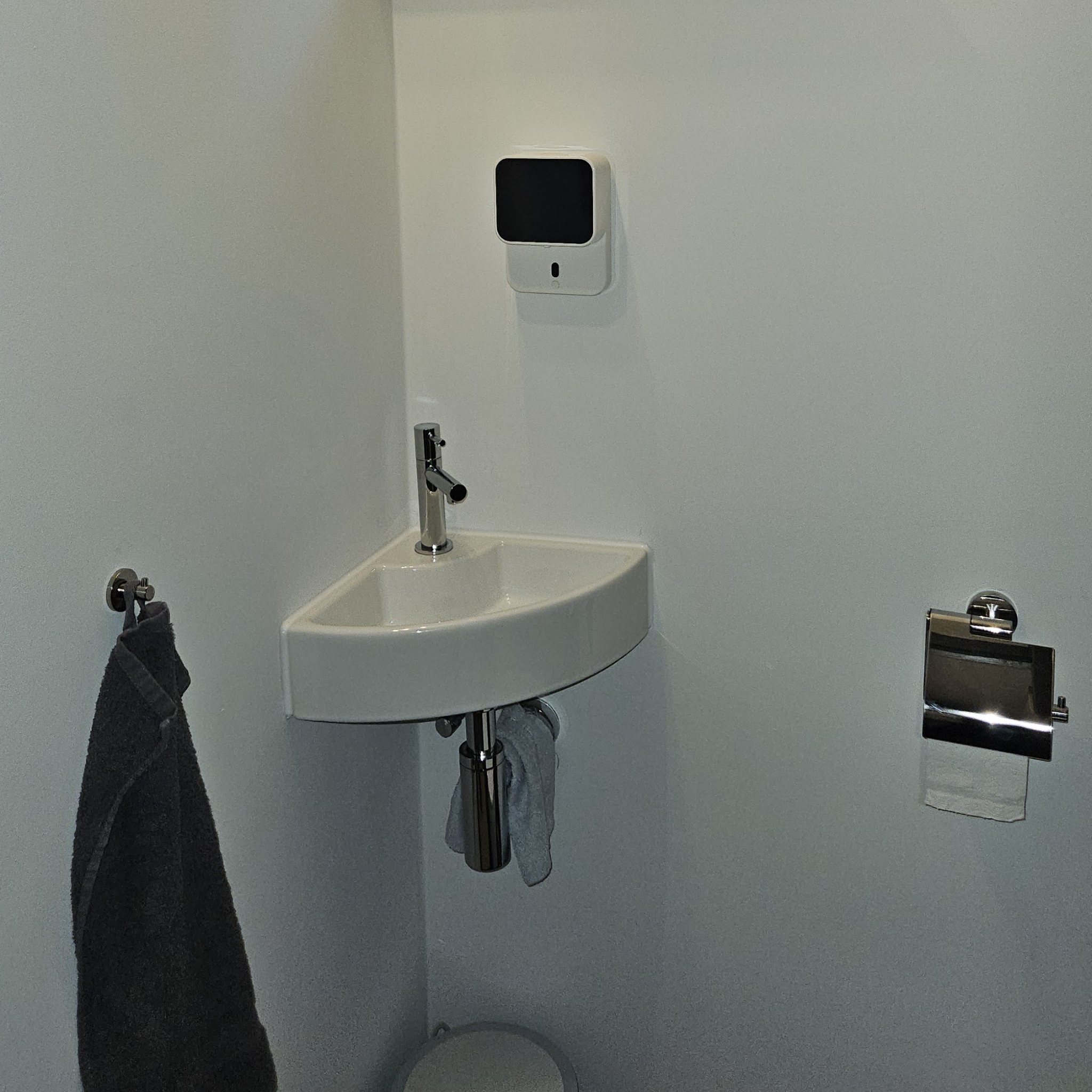 Hoekfontein met kraan en handdoek in het vernieuwde toilet